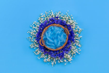 Blue digital background for newborns for photographers with a basket of flowers of lily of the valley and cornflower, fur.の写真素材