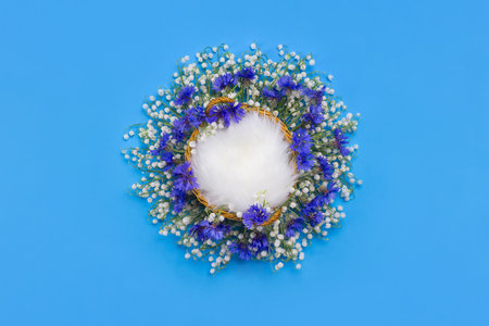 Blue digital background for newborns for photographers with a basket of flowers of lily of the valley and cornflower, fur.の写真素材