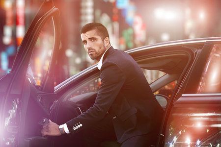 Portrait of an elegant man driving a car, luxury nightlife,.man in a car at night.