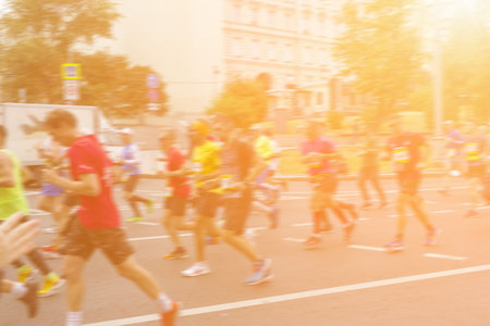 Marathon runners run through the city. A group of people on the move.の写真素材