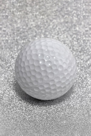Golf ball on a Christmas glitter background, close-up.の写真素材