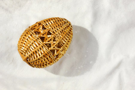 An Easter egg woven from straw lies on the table, top viewの写真素材