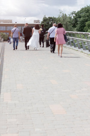 A group of people from behind and out of focus, a marriage ceremony going into the distance along the road, a wedding. Time concept.の写真素材
