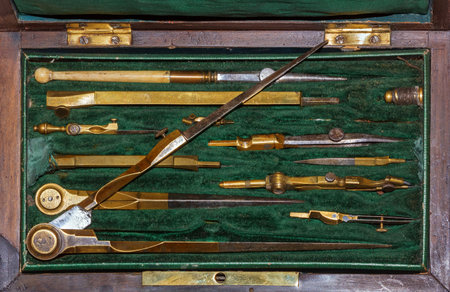 Old wooden case with green velvet with drawing tools lying on the table, top view.Case of drawing instruments.の写真素材