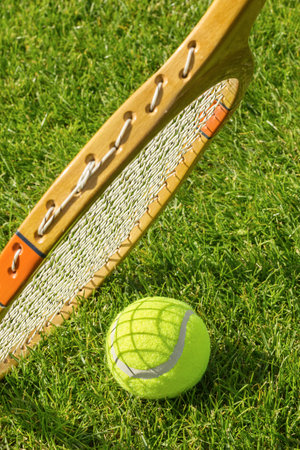 Racket and tennis ball on green grass. Sports, close-up.の写真素材