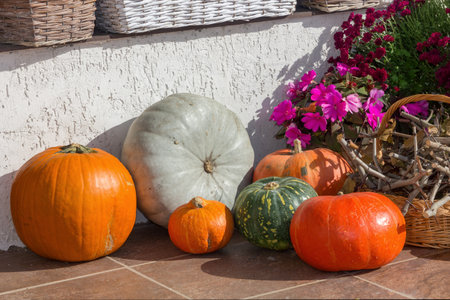 The porch of the house is decorated for Halloween with flowers and pumpkins, a sunny October day.の写真素材