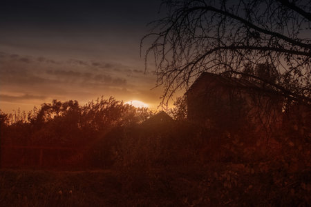 Spooky sunset in the countryside. Countryside landscape with an old cabin.の写真素材