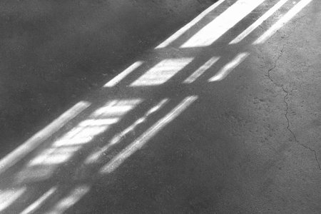 Rays of light and shadow on a gray, black background of a grunge concrete floor or wall. Rhetoric of dark forces, misfortune, fate.の写真素材