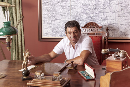 A man holding an important public position works at a desk in his retro-elite office. He looks at the camera.の写真素材
