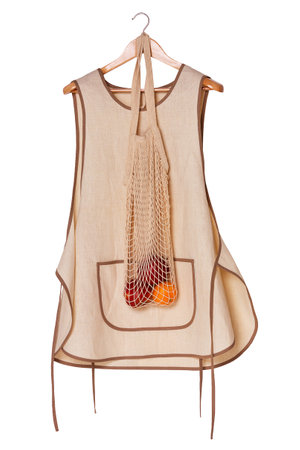 Kitchen linen eco-friendly women's apron on a wooden hanger. Front view. Isolated on white background.の写真素材