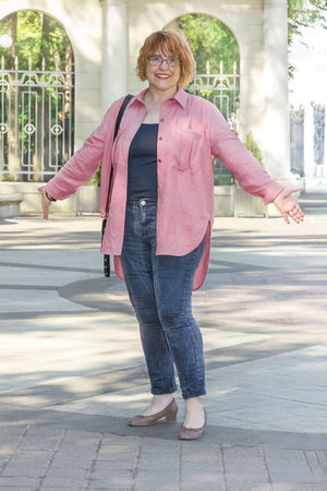 Full length portrait of plus size mature woman in casual style walking around the city on a nice sunny day. Life of a woman after 50 yearsの写真素材