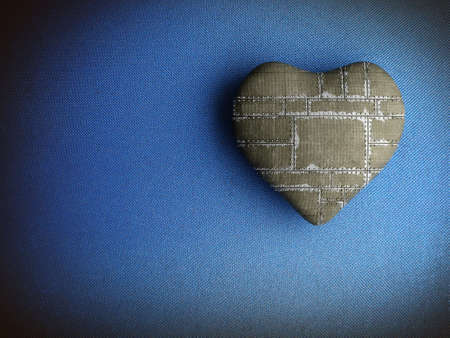 Patched heart on a dirty blue fabric backgroundの写真素材