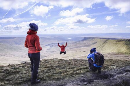 Girl jumping being a picture on a mountain top