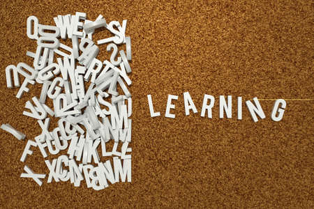 corckboard with white letters composing learning wordの写真素材