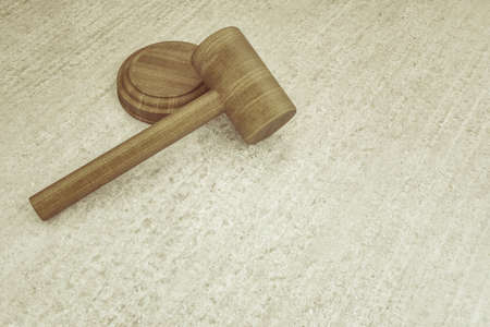 3d illustration of a wooden hammer on a concrete boardの写真素材