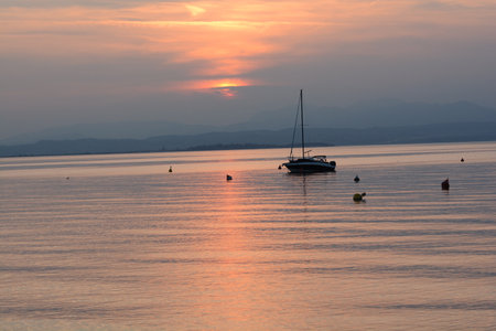 sunset with clouds on lake gardaの写真素材