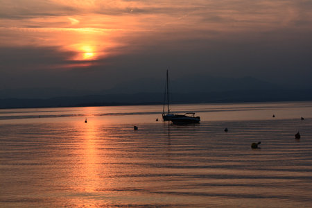 sunset with clouds on lake gardaの写真素材