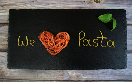 We love pasta, writing made from pasta arranged on a slate, horizontalの写真素材