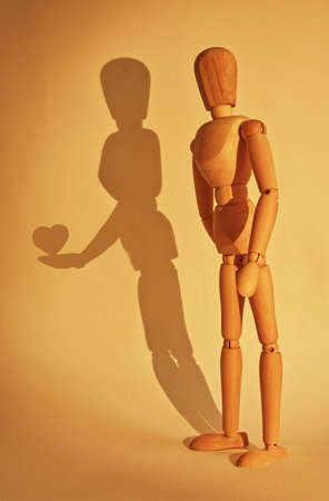 Illuminated wooden mannequin with false shadow, vertical, confess loveの写真素材