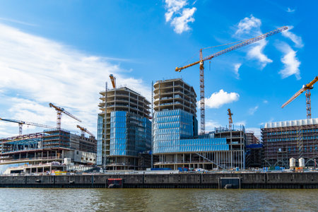 Hamburg, Germany- August 05, 2023: View from the water onto a construction site in the Hafencity of Hamburg, slightly cloudy blue sky, horizontalのeditorial素材