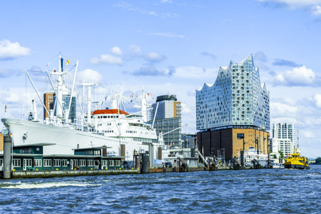 Hamburg, Germany- August 05, 2023: View from the water of the Elbphilharmonie and the museum ship in the port of Hamburg, slightly cloudy blue sky, horizontalのeditorial素材
