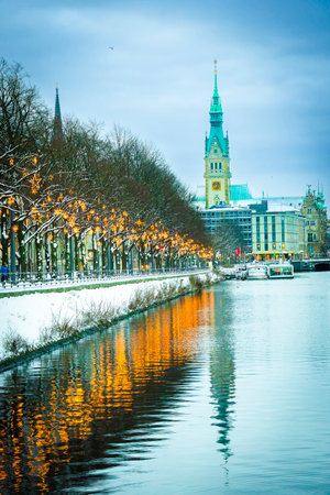 View along the Christmas-lit Ballindamm towards the town hall in Hamburg, reflections in the water, verticallyの写真素材