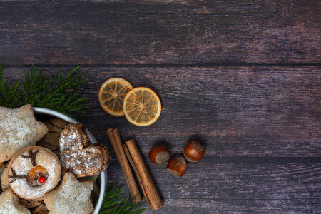 White porcelain bowl with Christmas cookies on dark wooden background, top view, horizontalの写真素材