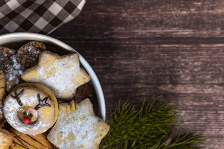 White porcelain bowl with Christmas cookies on red dark wooden background, top view, horizontalの写真素材