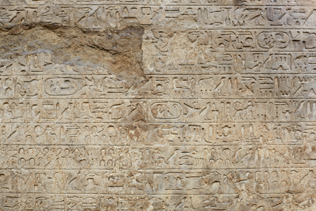 Egyptian hyerogliphs writing on old broken stone background