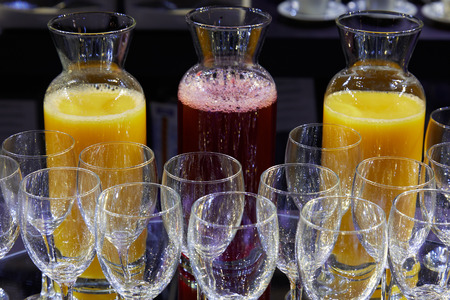 Red fruits and orange juice and crystal glasses ready for hotel breakfastの写真素材