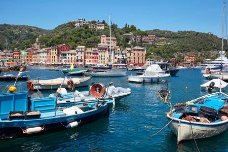Portofino typical beautiful village with colorful houses in Italy, fishing boats and Liguria sea coastの写真素材