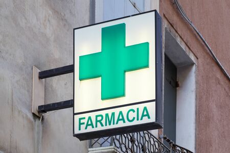 VENICE, ITALY - AUGUST 13, 2017: Pharmacy, farmacia sign with green illuminated cross in Italyのeditorial素材