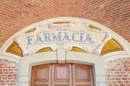 Vicoforte, Italy - August 17, 2016: Arcade in red bricks around Sanctuary of Vicoforte church, ancient pharmacy sign in Piedmont, Italyのeditorial素材