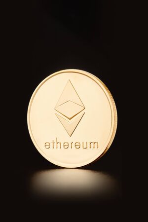 Golden Ethereum coin, cryptocurrency on black, clipping path
