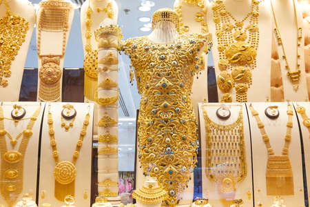DUBAI, UNITED ARAB EMIRATES - NOVEMBER 21, 2019: Dubai gold souk market window with jewellery, necklaces, bracelets and golden dressのeditorial素材
