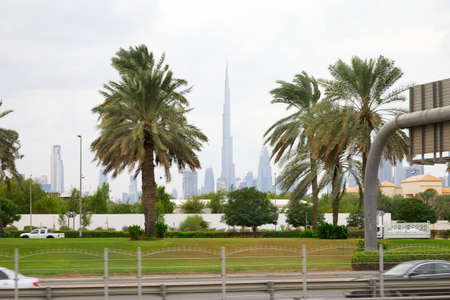 Dubai skyline, Burj Khalifa skyscraper and palm trees in a cloudy dayのeditorial素材