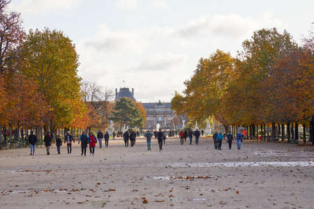 PARIS - NOVEMBER 7, 2019: Tuileries garden, walk with people in a sunny autumn day in Paris, brown foliageのeditorial素材