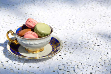Macarons biscuits with ceramic cup with blue and golden decorationsの写真素材