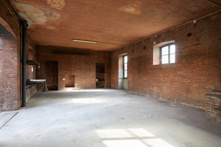 Old, empty workshop interior with red brick walls, sunlightの写真素材