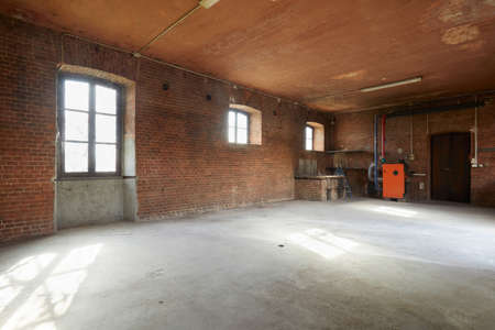 Old workshop interior with brick walls and windows, sunlightの写真素材