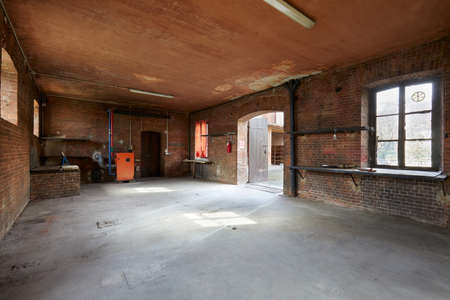 Old, empty workshop interior with brick walls in a sunny morningの写真素材