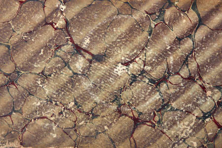 Old paper background with brown, green, and red abstract design texture backgroundの写真素材
