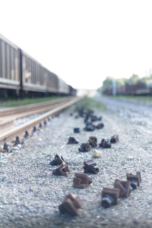 Close Up Narrow shot of a railway metal locks on the ground close to a freight train in a italian...