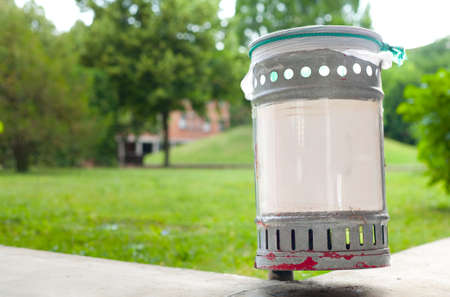 Small iron garbage can in public park with white plastic sign editable textの写真素材