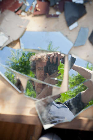 Self portrait with brookern mirror and reflex camera on wooden boxのeditorial素材