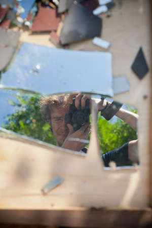 Self portrait half body with brookern mirror and reflex camera on wooden box