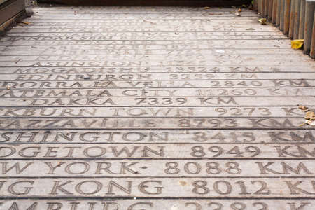 Wooden bridge with engraved geographical distances of world capitals from istanbul turkey to dakkaの写真素材
