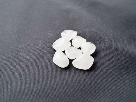 Tumbled milky Quartz stones for crystal therapy treatments and reiki on blackの写真素材