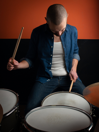 Young boy playing drum with jeans shirtの写真素材