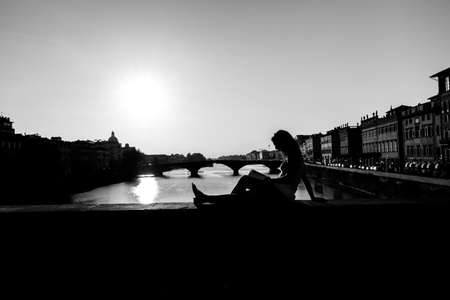 Girl reading book outdoors at sunset time, florence, italyの写真素材